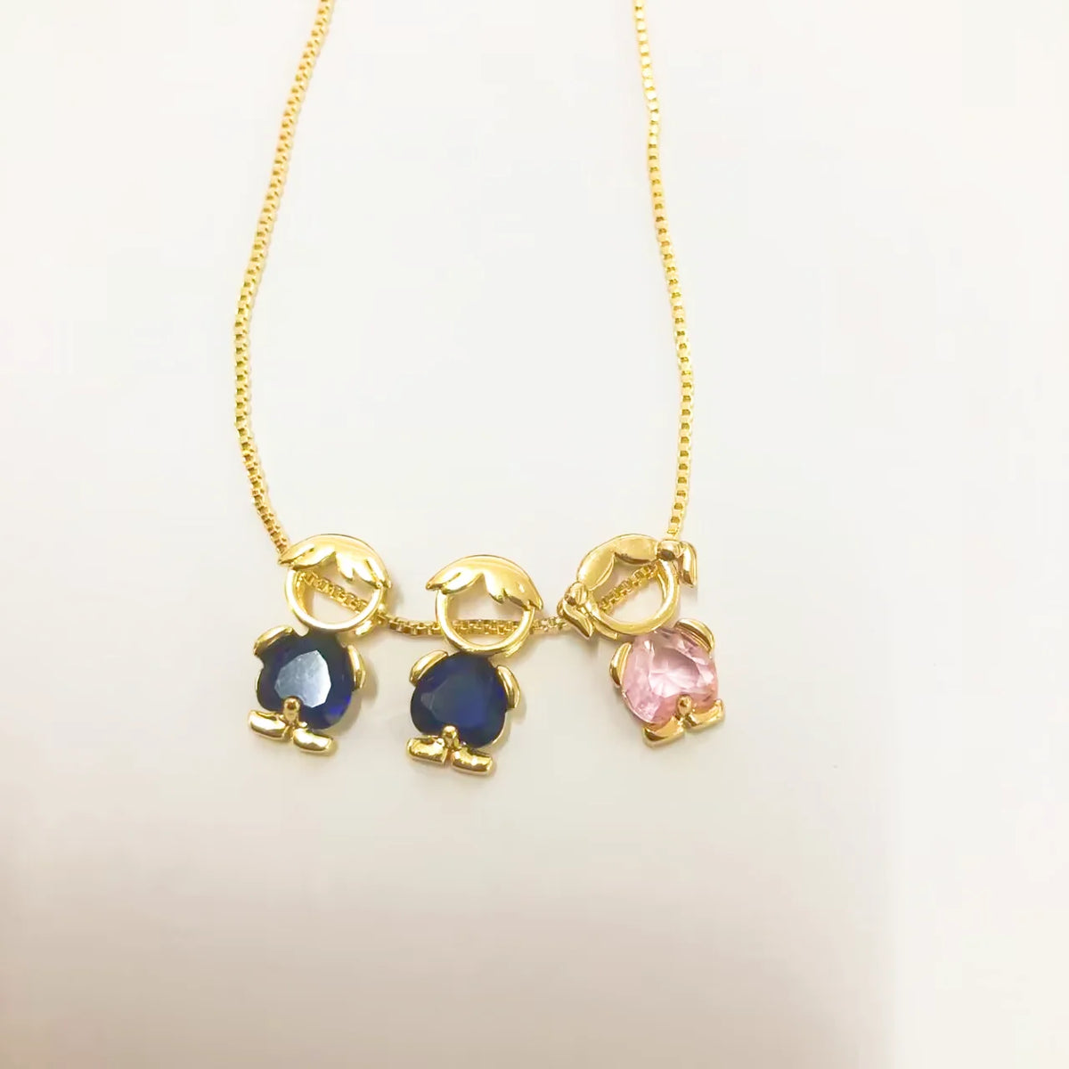 Collar Familia con tres figuritas: dos niños con piedra azul y una niña con piedra rosa
