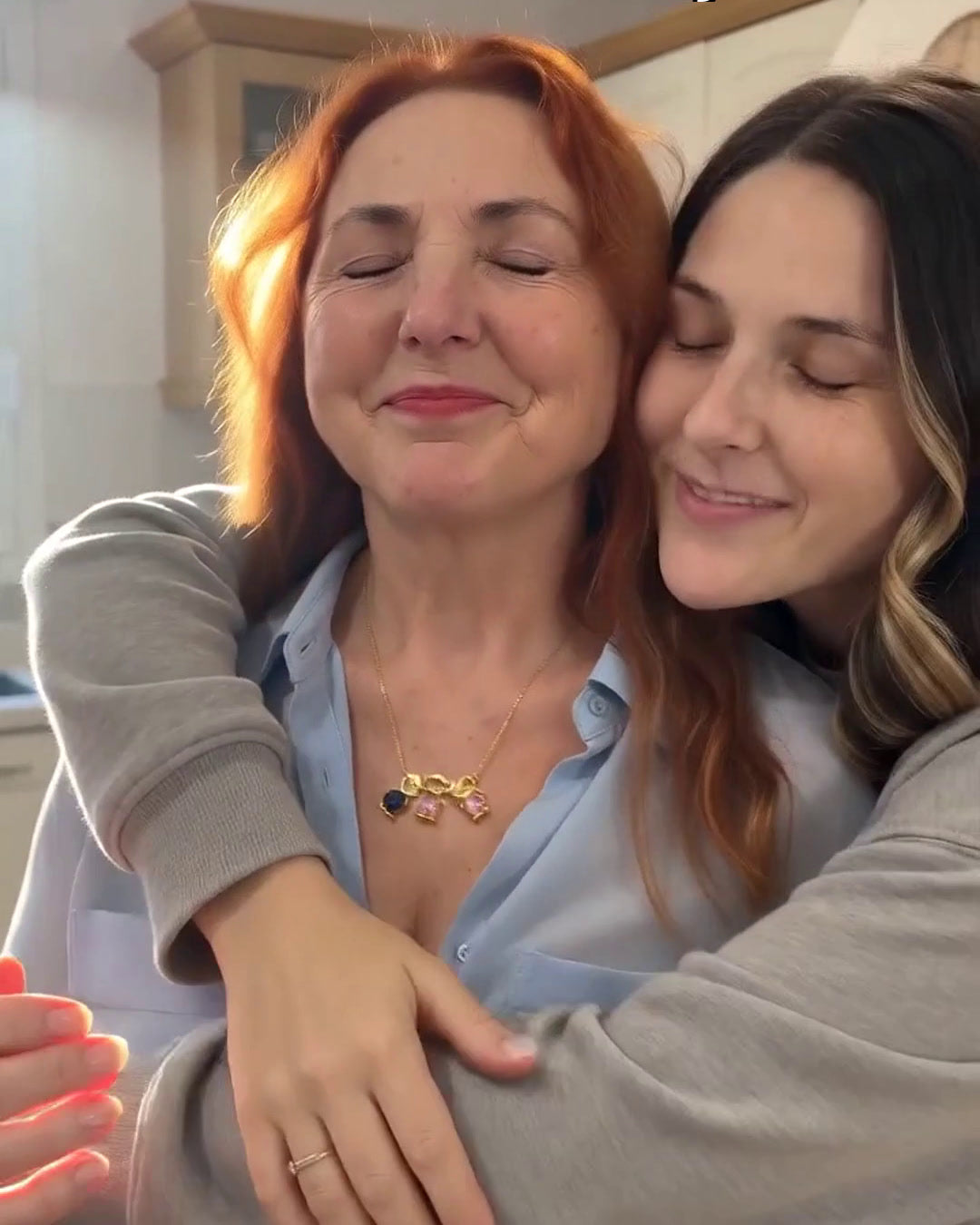 Hija abrazando a su madre, que lleva el collar La Nova